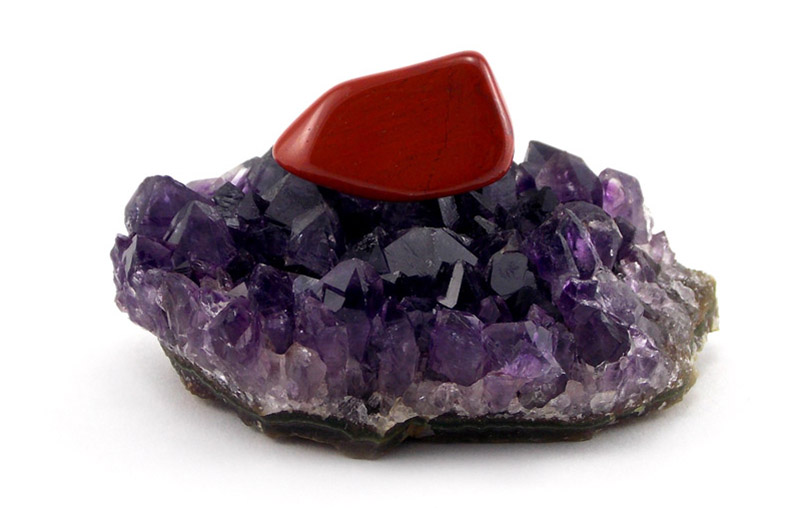 Pierre de jaspe rouge se rechargeant sur un amas d'améthyste